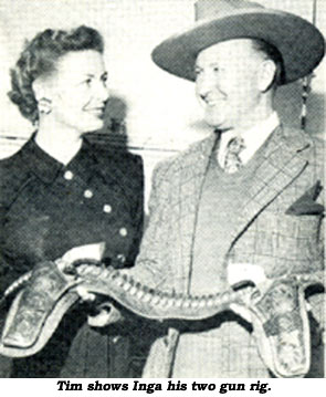 Tim McCoy shows wife Inga Arvad his two gun rig.