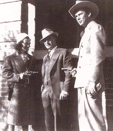 Husband and wife Jan Clayton (L) and Russell Hayden (R) put a six-gun hold on Jan's real-life father O. M. "Jack" Voyde (center) during a simulated western desperado day in Alamagordo, New Mexico, just a few miles from Jan's hometown of Tularosa.