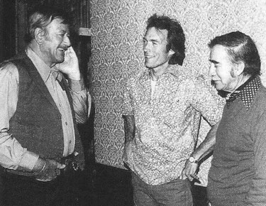 Clint Eastwood and director Don Siegel visit with John Wayne on the 
set of “The Shootist”. 