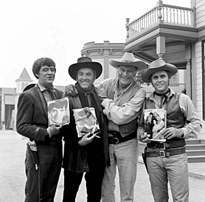 On location in Arizona, holding their cast photos, are (L-R) Henry Darrow, Cameron Mitchell, Leif Erickson, Mark Slade. 