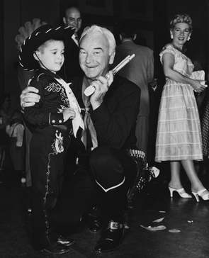 William "Hopalong Cassidy" Boyd with a devout Hoppy fan. Boyd's wife Grace Bradley stands in the background.