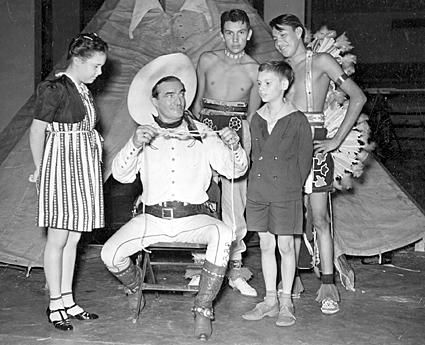 Tom Mix shows a few of his young fans some tricks with a rope