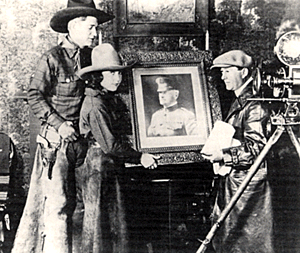 Silent star Art Acord and Marcella Pershing with a photo of her cousin, General John J. "Blackjack" Pershing, and William J. Craft, director of "The Show Down" ('21) starring Art and Marcella.