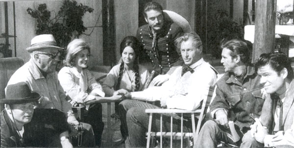 Relaxing between takes of “Pyramids of the Sun God”, filmed in Yugoslavia in ‘65, are (L-R) Ralf Wolter, director Robert Siodmak, Tita Barker, Theresa Lorca, Rik Battaglia, Lex Barker , Gustavo Rojo and Kelo Henderson (former star of TV’s “26 Men”).