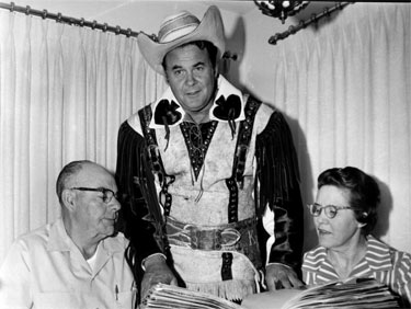 Sunset Carson, back from a 10 year world tour, shows his bulging scrapbook filled with press clippings to Thrane and Imogene Parsons during a 1967 visit to their home in Plainview, TX. (Thanx to Bobby Copeland.) 