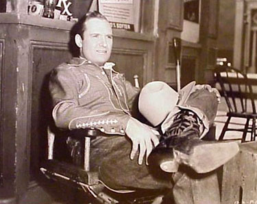 Gene Autry takes a break on a drugstore set. (Thanx to Jerry Whittington.)