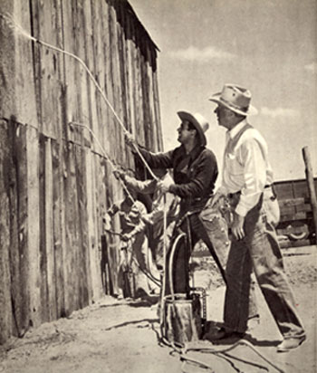 Producer Harry “Pop” Sherman watches star Don DeFore use a spray hose to set fire to a wooden building for the burning sequence in “Ramrod” (‘47 U.A.).