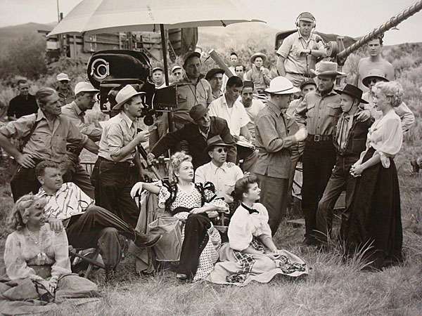 Main cast and crew of “Roughshod” (‘49 RKO). Seated left: Jeff Donnell, seated middle front: Myrna Dell, Martha Hyer. Director Mark Robson standing with white hat talks to Robert Sterling, Claude Jarman Jr. and Gloria Grahame. Camera operator was James Daly and cinematographer was Joseph Biroc (likely man in white hat by camera.) (Thanx to Leonard Maltin.)