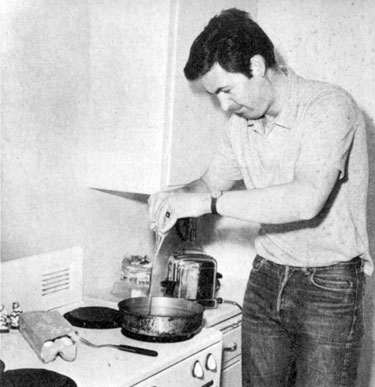 “Davy Crockett”, Fess Parker scrambles an egg to satisfy his hearty appetite.